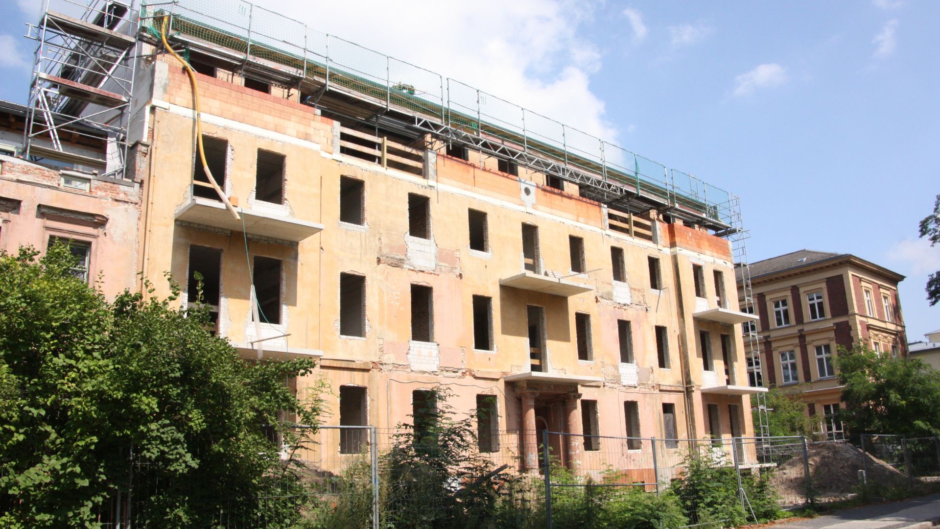 Baustelle von neuem Wohngebäude mit mehreren Stockwerken und Balkonen