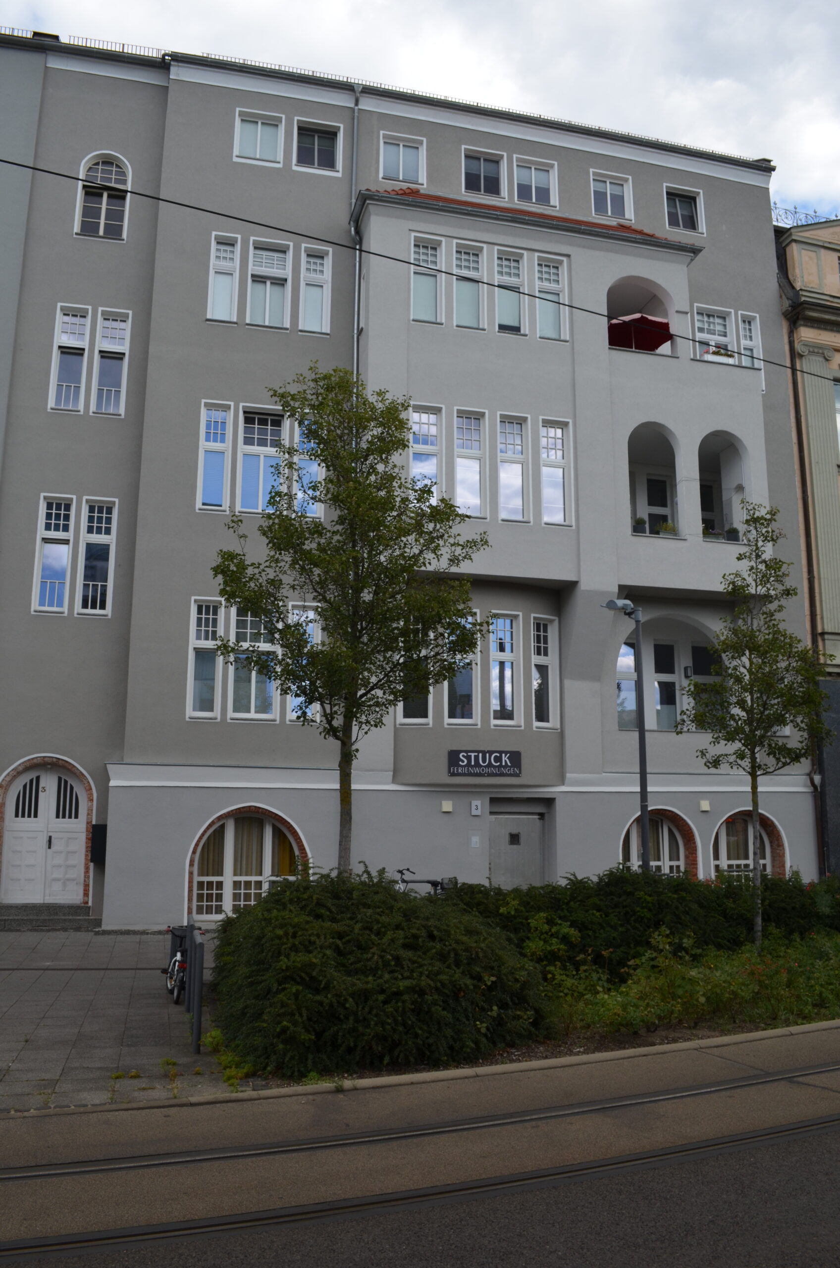 Planungsbüro Stuck: Moderne graue Fassade mit großen Fenstern und Bäumen